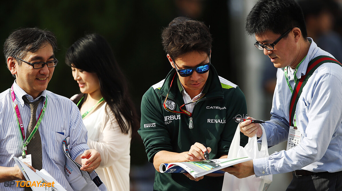 Suzuka Circuit, Suzuka, Japan. 
Friday 3 October 2014.
Kamui Kobayashi, Caterham F1, signs autographs for fans.
World Copyright: Charles Coates/LAT Photographic.
ref: Digital Image _N7T6760





formula 1 formula one f1 gp
