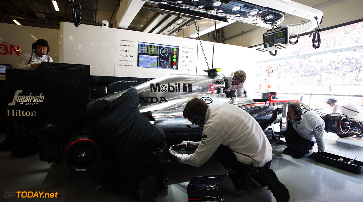 McLaren mechanics work on Jenson Button's car.