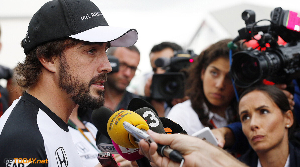 Fernando Alonso talks to the media in the paddock.