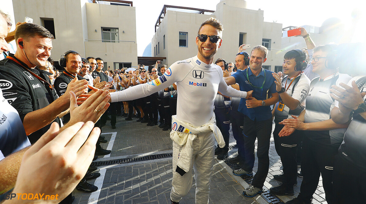 Jenson Button walks to the garage to the cheers of his team.